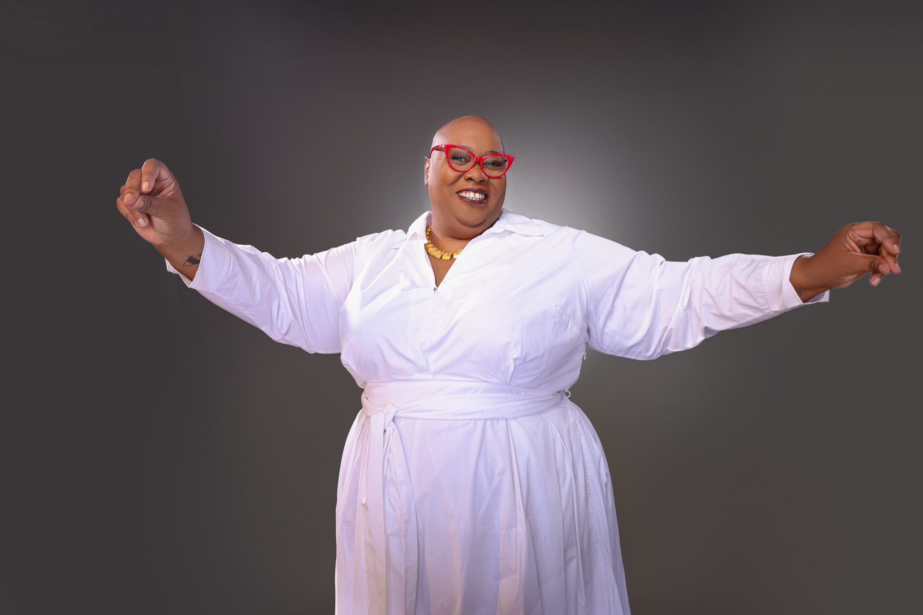 Dr. Adriane Johnson-Williams smiling confidently with her arms outstretched